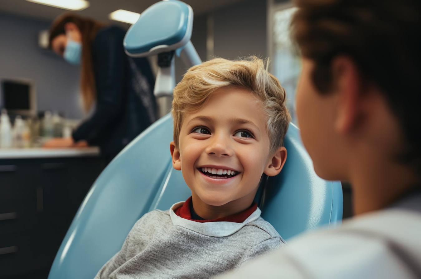 Smiling child in dental chair at pediatric dentist office, illustrating a positive first dental visit experience.